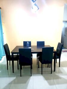 a dining room table and chairs in a room at OYO HOME 90768 Flo Inn Motel in Tawau
