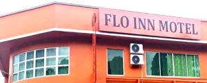 un edificio anaranjado con un letrero que lee el modelo de gripe im en OYO HOME 90768 Flo Inn Motel en Tawau