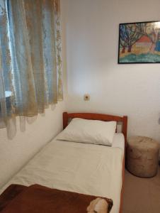 a small bed in a room with a window at Apartments Vila Lavanda in Omišalj