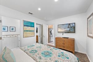 a bedroom with a bed and a dresser in it at Villa Lanai at the Sunset Cove Villas in Laguna Beach