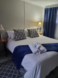 a bedroom with a large bed with towels on it at Riebeeck Cottage in Potchefstroom