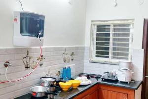 a kitchen with a counter top with pots and pans at Servostay 2 Bhk Fully Furnished in Hafeezpet #202 in Hyderabad +7 photos