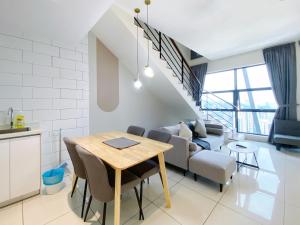 een keuken en een woonkamer met een tafel en een bank bij Arte Mont Kiara By Awesomestay in Kuala Lumpur
