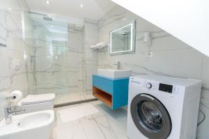 y baño con lavadora y lavamanos. en Hakuna Matata Residence & Apartments, en Vlorë