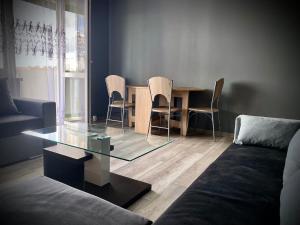 a living room with a glass table and chairs at Słoneczny Apartament Libiąż in Libiąż