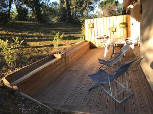 eine Holzterrasse mit einem Tisch und Stühlen darauf in der Unterkunft Village Vacances aux Villages sous les Pins in Léon