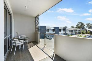 a balcony with a table and chairs and a building at Platinum International in Toowoomba