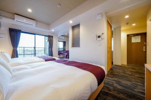 a hotel room with two beds and a balcony at RESI STAY Gojozaka in Kyoto