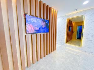 Astar Hotel Bukit Bintang في كوالالمبور: غرفة معيشة مع تلفزيون على الحائط