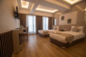 een hotelkamer met 2 bedden en een bureau bij Vera Life Hotel in Istanbul