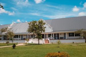 a large white building with a gray roof at Kili Seasons Hotel in Arusha