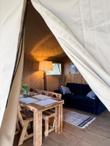 a living room with a couch and a table in a tent at Wioska Wakacyjna Glamila in Sterławki Wielkie