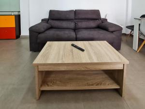 een afstandsbediening bovenop een houten salontafel bij Apartamento Completo Vera Rincon de Loix in Benidorm