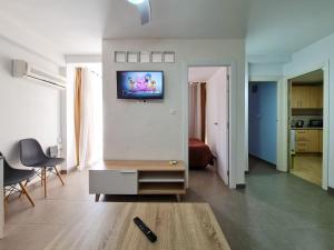 een woonkamer met een tv aan de muur bij Apartamento Completo Vera Rincon de Loix in Benidorm