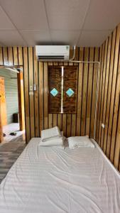 a bedroom with a large white bed with wooden walls at Style Motorbikes Homestay Ha Giang in Ha Giang