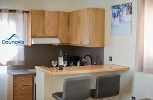 une cuisine avec des armoires en bois et deux verres de vin dans l'établissement Dounavis Homes: The Hidden Olive, à Ermoúpoli 13 autres photos