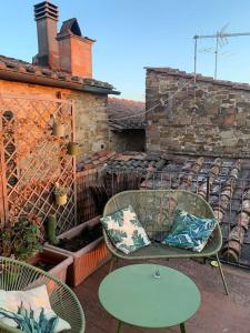 een patio met 2 stoelen, een tafel en een hek bij La tua casa nel Chianti in San Donato in Poggio
