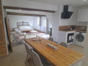 a living room with a wooden table and a kitchen at Gite de l'épine in Haute-Épine