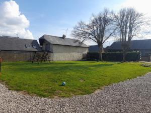 un patio con una casa y una casa con una pelota en el césped en Gite de l'épine, en Haute-Épine