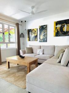 a living room with a couch and a coffee table at Villa sur la plage de Mont-Choisy in Trou aux Biches