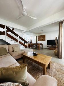 a living room with a couch and a table at Villa sur la plage de Mont-Choisy in Trou aux Biches