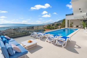 a villa with a swimming pool and lounge chairs at Luxury Villa Sagnia, 4 en-suite bedrooms, sea views in Makarska