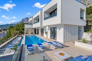 a villa with a swimming pool and a house at Luxury Villa Sagnia, 4 en-suite bedrooms, sea views in Makarska +56 photos