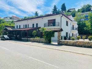 a white building on the side of a street at Fuk-tak apartmani&restoran in Star Dojran