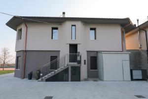 Biały dom ze schodami przed nim w obiekcie Alloggi alla Rotonda 
