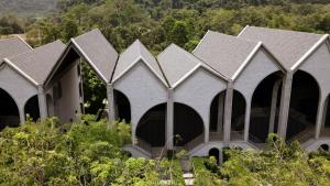 a row of houses with arched windows in a forest at Hotel Labaris Khao Yai in Mu Si