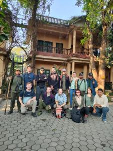 un grupo de personas posando para una foto frente a una casa en Wild Horizons Guest House, en Sauraha