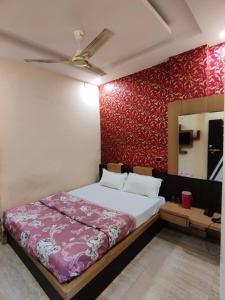 a bedroom with a bed and a red wall at HOTEL SUKHMANI in Guwahati