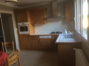 a kitchen with wooden cabinets and a sink at Gite de Saint Jean in Saint-Jean-de-Thouars +22 photos