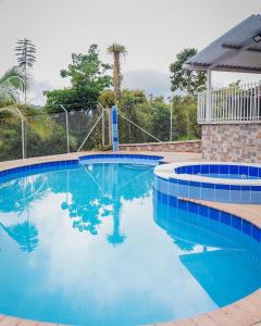 a swimming pool with blue water in a yard at Hotel Campestre Villa Mary in Santa Rosa de Cabal