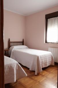 1 dormitorio con 2 camas y ventana en Casa Balbi, en Canales