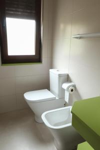 ein weißes Bad mit einem WC und einem Fenster in der Unterkunft Casa Balbi in Canales