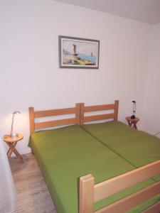 1 dormitorio con 1 cama con colcha verde en Apartment Pink Mimosa, en Malinska