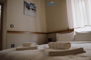 une chambre avec un lit avec des serviettes dessus dans l'établissement Dounavis Homes: The Hidden Olive, à Ermoúpoli
