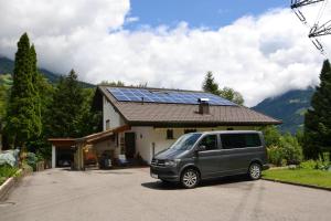 ein Van vor einem Haus mit Sonnenkollektoren geparkt in der Unterkunft Ruhepol in Schruns-Tschagguns