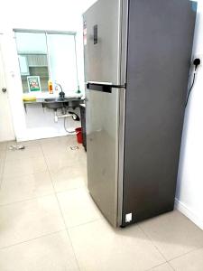 a stainless steel refrigerator in a kitchen at OYO HOME 90769 Flo Inn Homestay Bsi in Tawau