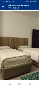 Una foto de dos camas en una habitación en ADDRESS service apartment, en Bangalore