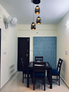 comedor con mesa negra y sillas en ADDRESS service apartment, en Bangalore