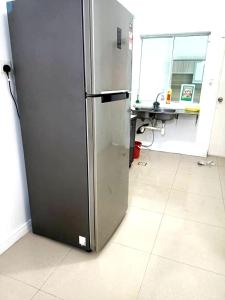 a stainless steel refrigerator in a room at OYO HOME 90769 Flo Inn Homestay Bsi in Tawau