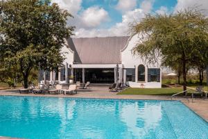 a swimming pool in front of a house at Kili Seasons Hotel in Arusha