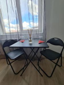 Una mesa y dos sillas frente a una ventana. en Garsoniera - moderna - Timișoara, en Timisoara