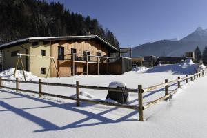 ein Holzzaun im Schnee vor einem Gebäude in der Unterkunft Ferienhaus Silber in Bartholomäberg