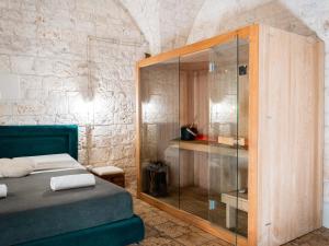a bedroom with a glass shower and a bed at Dama Bianca Boutique Hotel Ostuni in Ostuni