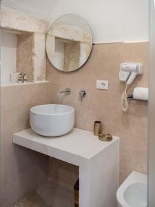 a bathroom with a sink and a mirror on the wall at Dama Bianca Boutique Hotel Ostuni in Ostuni