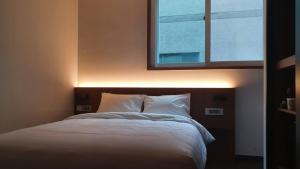 Postel nebo postele na pokoji v ubytování Pillowsopher Hongdae