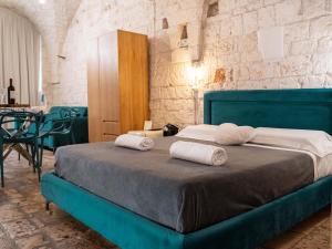 a bedroom with a blue bed with two pillows on it at Dama Bianca Boutique Hotel Ostuni in Ostuni